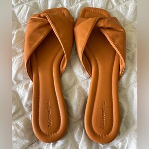 Reformation Mikki Twist sandal flat in caramel orange color